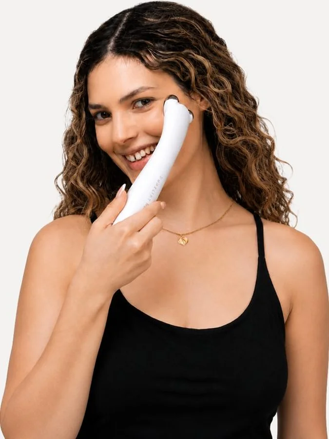 Smiling woman gliding PureLift Pro Edition over her cheek
